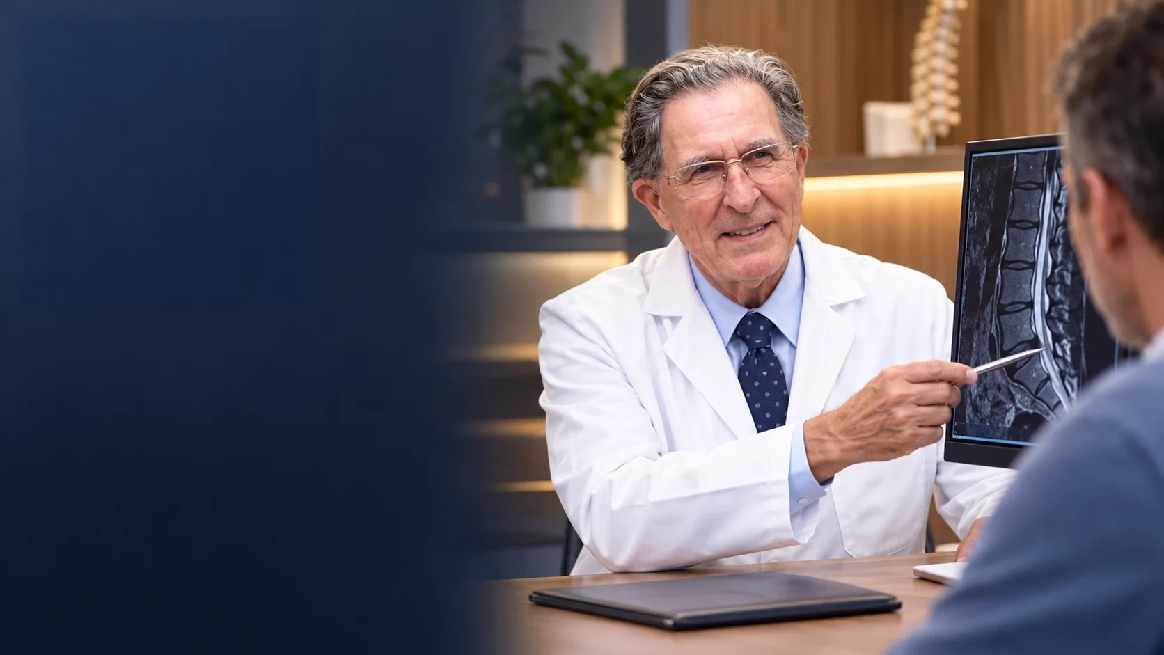 A spine specialist reviewing spinal imaging with a patient